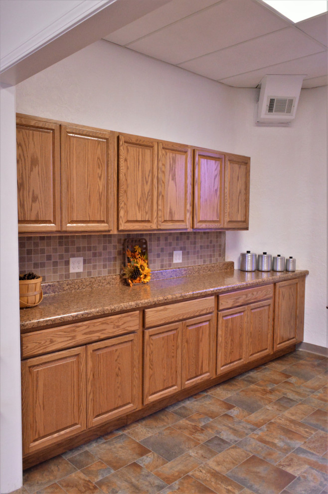Exempel på ett mellanstort rustikt brun linjärt brunt kök och matrum, med en nedsänkt diskho, luckor med upphöjd panel, skåp i ljust trä, laminatbänkskiva, brunt stänkskydd, rostfria vitvaror, laminatgolv och flerfärgat golv