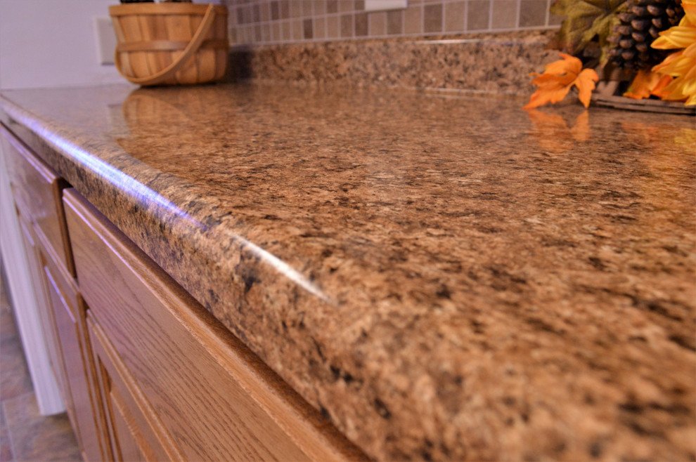 Inredning av ett rustikt mellanstort brun linjärt brunt kök och matrum, med en nedsänkt diskho, luckor med upphöjd panel, skåp i ljust trä, laminatbänkskiva, brunt stänkskydd, rostfria vitvaror, laminatgolv och flerfärgat golv