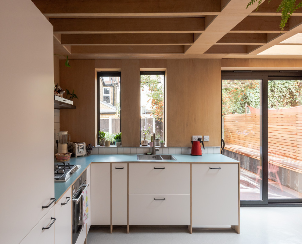 На фото: кухня в стиле ретро с деревянной столешницей и синей столешницей с