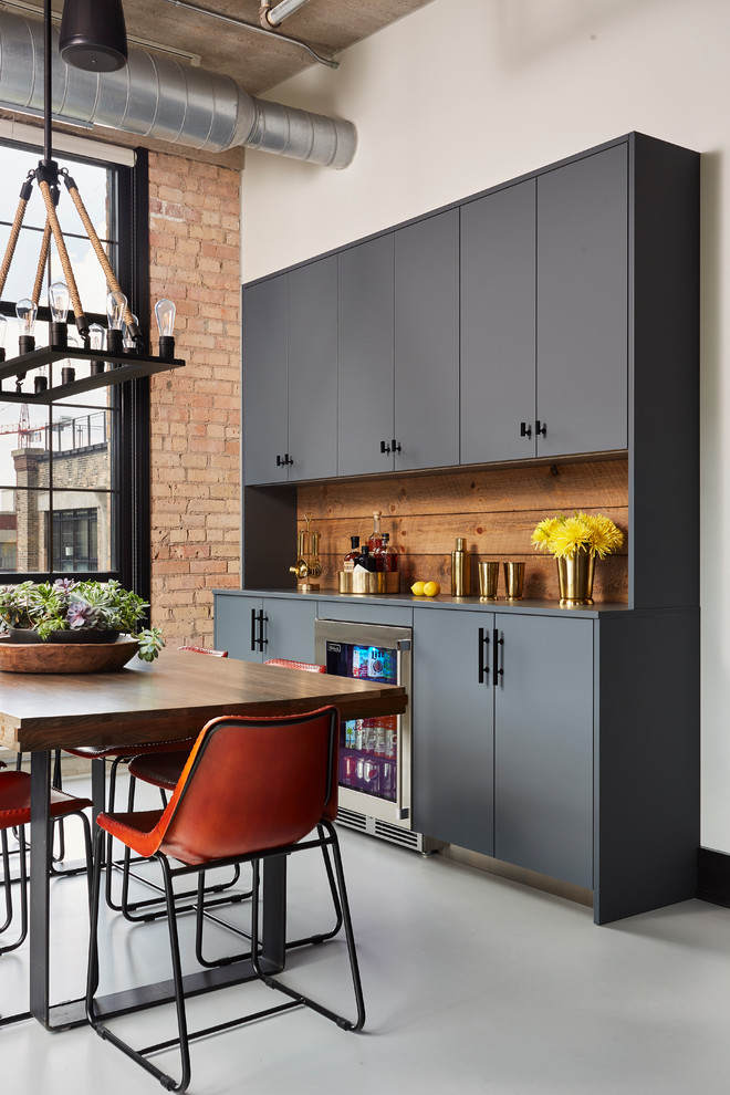 Imagen de cocina industrial con puertas de armario grises, electrodomésticos de acero inoxidable y encimeras blancas