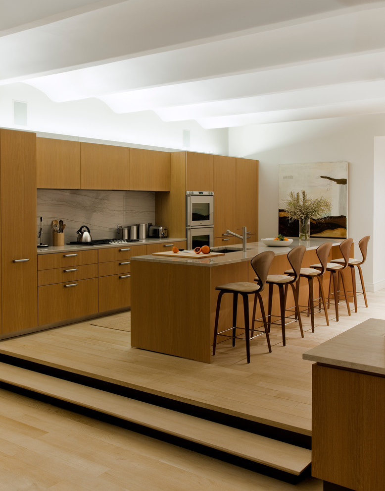 Стильный дизайн: параллельная кухня в стиле модернизм с фасадами цвета дерева среднего тона, обеденным столом, врезной мойкой, плоскими фасадами, фартуком из каменной плиты и коричневым фартуком - последний тренд