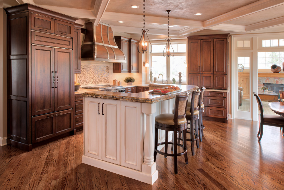 Example of a large classic l-shaped medium tone wood floor eat-in kitchen design in Minneapolis with an undermount sink, recessed-panel cabinets, dark wood cabinets, beige backsplash, ceramic backsplash, stainless steel appliances and an island