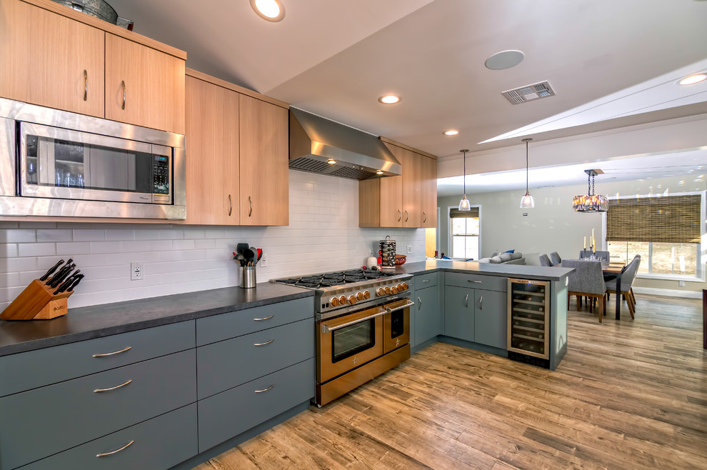 Example of a large transitional u-shaped medium tone wood floor eat-in kitchen design in San Francisco with an undermount sink, flat-panel cabinets, subway tile backsplash, stainless steel appliances, blue cabinets, white backsplash and a peninsula
