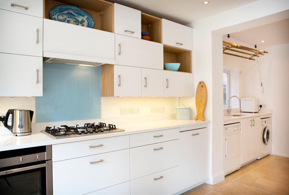 Imagen de cocina comedor lineal moderna pequeña con armarios con paneles lisos, puertas de armario blancas y encimera de granito