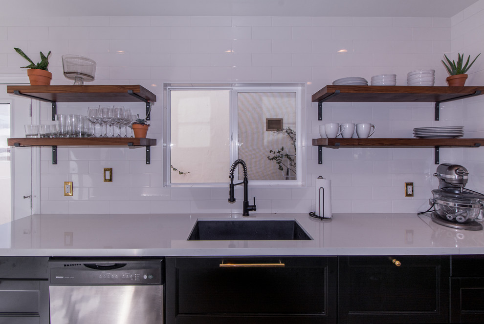 Modern inredning av ett mellanstort linjärt kök med öppen planlösning, med en undermonterad diskho, skåp i shakerstil, svarta skåp, bänkskiva i koppar, vitt stänkskydd, stänkskydd i tunnelbanekakel, rostfria vitvaror och klinkergolv i porslin