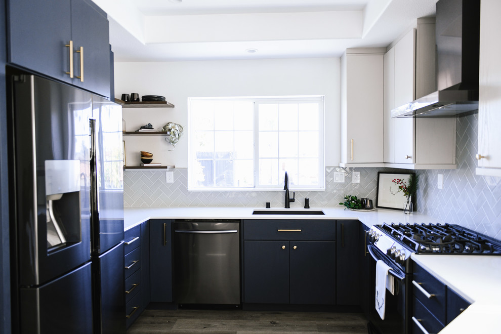 Exempel på ett mellanstort modernt vit vitt kök, med en undermonterad diskho, släta luckor, blå skåp, bänkskiva i kvarts, grått stänkskydd, stänkskydd i keramik, svarta vitvaror, vinylgolv, en halv köksö och grått golv
