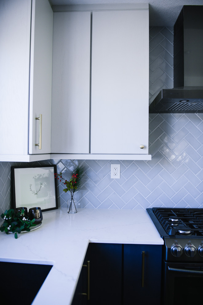 サンディエゴにある高級な中くらいなモダンスタイルのおしゃれなキッチン (アンダーカウンターシンク、フラットパネル扉のキャビネット、青いキャビネット、クオーツストーンカウンター、グレーのキッチンパネル、セラミックタイルのキッチンパネル、黒い調理設備、クッションフロア、グレーの床、白いキッチンカウンター) の写真