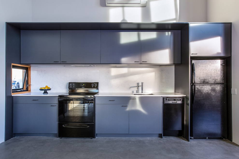 Foto de cocina retro abierta con armarios con paneles lisos, puertas de armario grises, suelo de cemento, suelo gris y encimeras blancas
