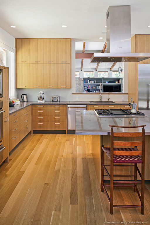 Свежая идея для дизайна: п-образная кухня в современном стиле с обеденным столом, врезной мойкой, фасадами с утопленной филенкой, светлыми деревянными фасадами и техникой из нержавеющей стали - отличное фото интерьера