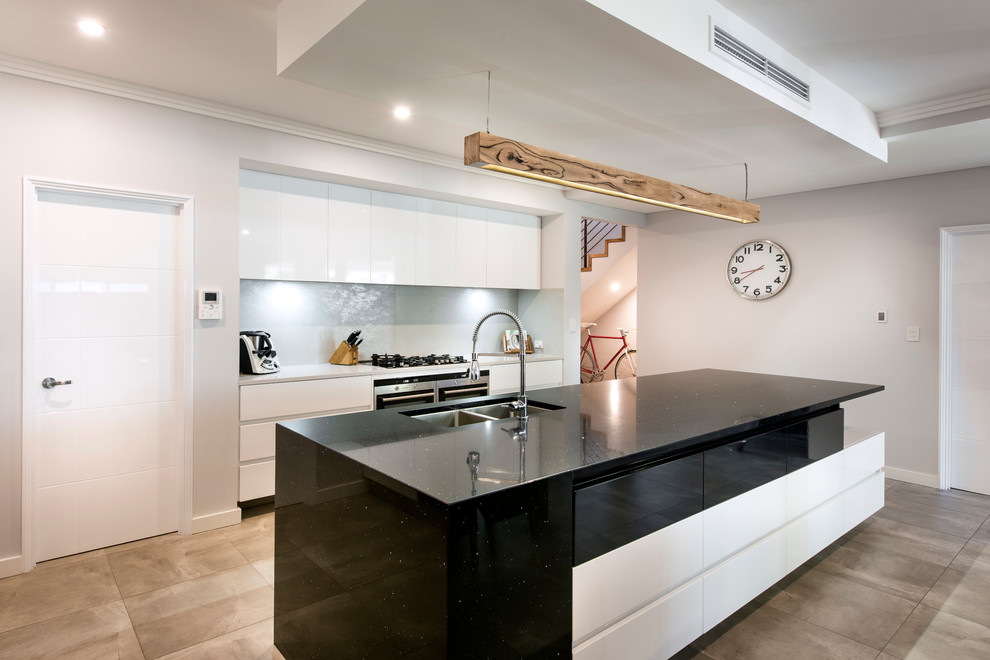 This is an example of a medium sized contemporary single-wall open plan kitchen in Perth with a submerged sink, flat-panel cabinets, white cabinets, engineered stone countertops, grey splashback, porcelain splashback, stainless steel appliances and an island.