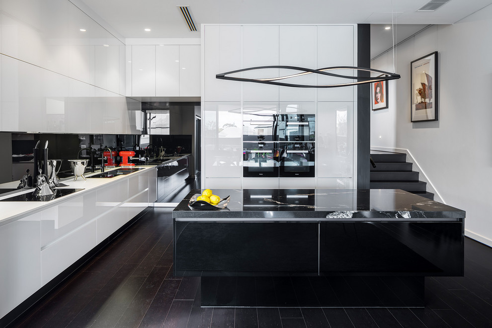 Große Moderne Küche mit Küchenrückwand in Schwarz, Glasrückwand, schwarzen Elektrogeräten, Kücheninsel, weißer Arbeitsplatte, Unterbauwaschbecken, flächenbündigen Schrankfronten, weißen Schränken und braunem Boden in Perth