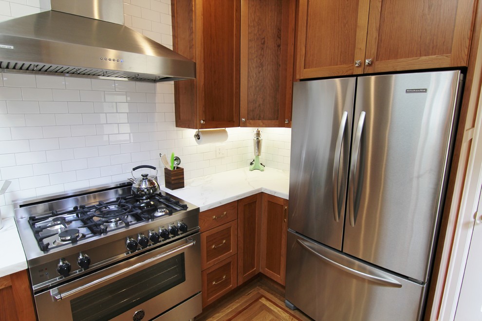 Example of a mid-sized classic galley medium tone wood floor eat-in kitchen design in San Francisco with a single-bowl sink, shaker cabinets, medium tone wood cabinets, marble countertops, white backsplash, ceramic backsplash, stainless steel appliances and a peninsula
