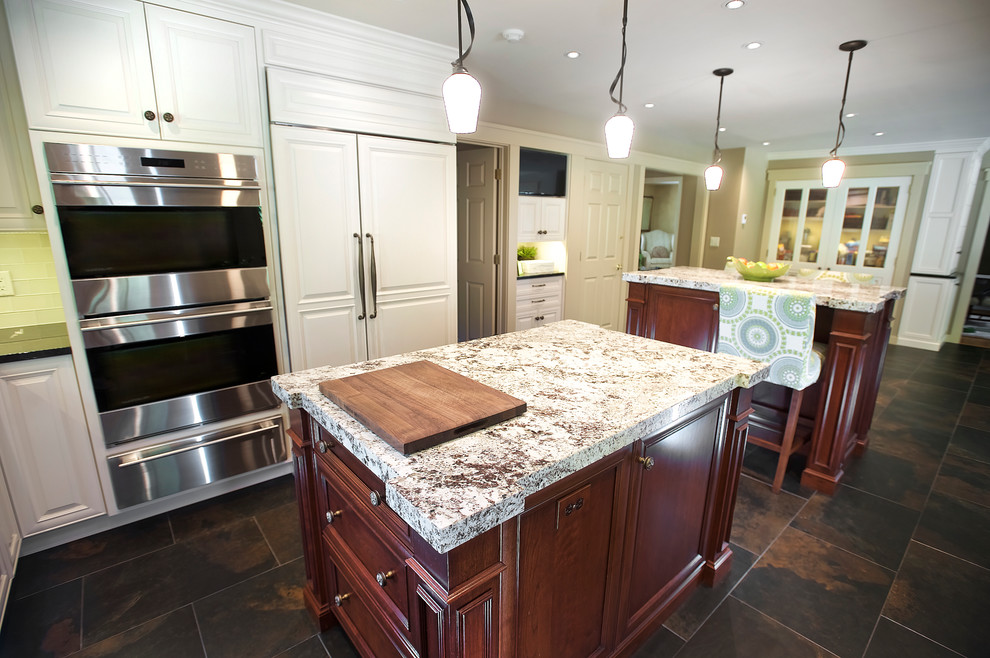Eat-in kitchen - large traditional u-shaped slate floor and brown floor eat-in kitchen idea in Las Vegas with an undermount sink, beaded inset cabinets, white cabinets, quartzite countertops, white backsplash, glass tile backsplash, stainless steel appliances and two islands