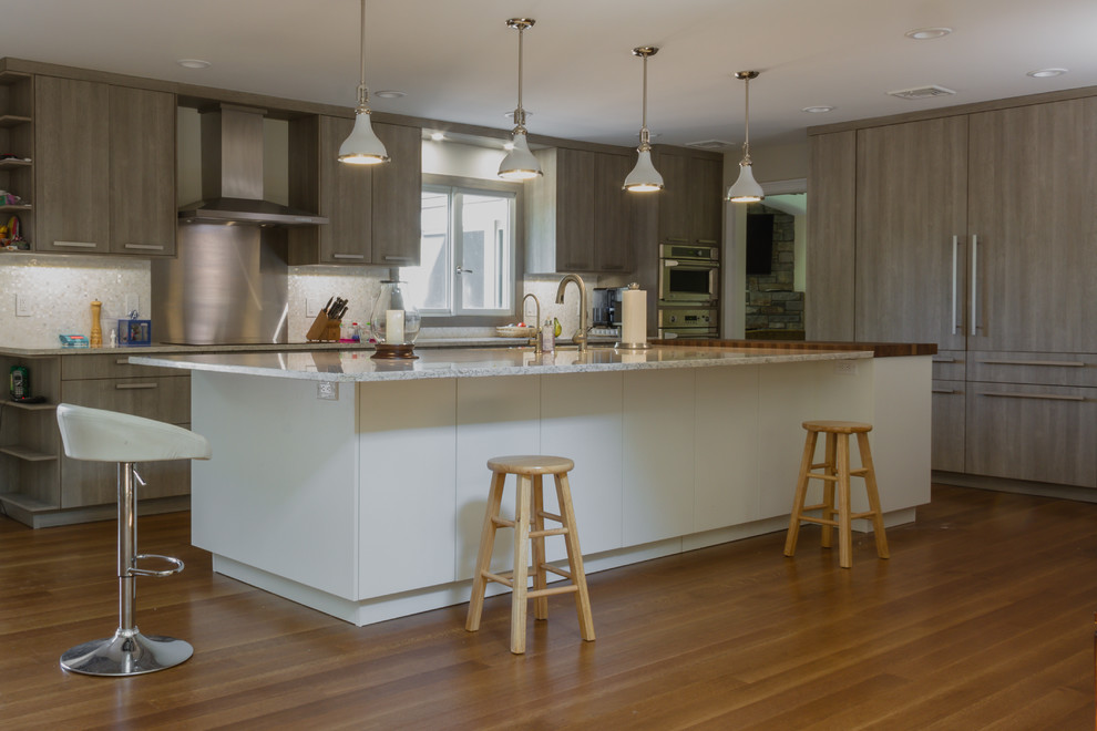 Exempel på ett stort modernt kök, med en köksö, släta luckor, skåp i ljust trä, bänkskiva i kvarts, vitt stänkskydd, stänkskydd i mosaik, rostfria vitvaror, en undermonterad diskho och mellanmörkt trägolv