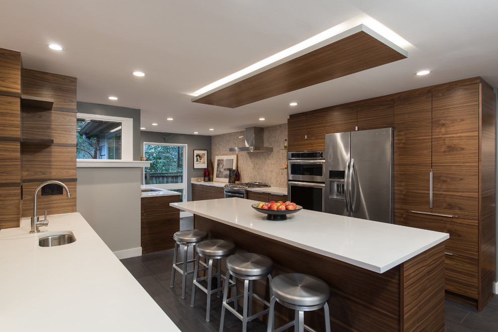 Moderne Küche mit Unterbauwaschbecken, flächenbündigen Schrankfronten, dunklen Holzschränken, Küchenrückwand in Beige und Küchengeräten aus Edelstahl in Seattle