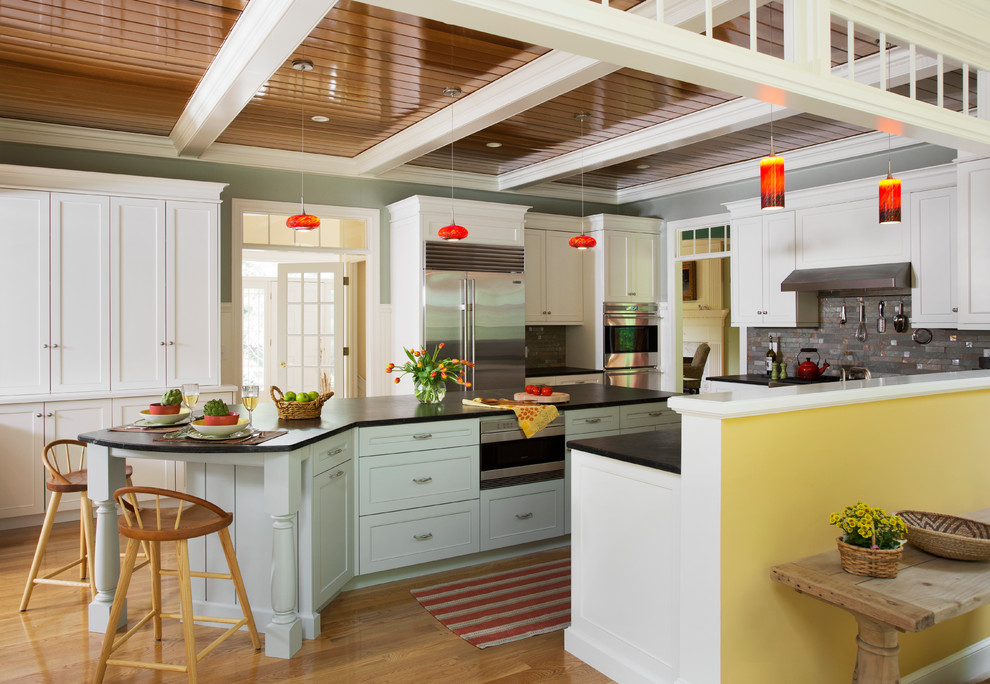 Imagen de cocina clásica cerrada con electrodomésticos de acero inoxidable, encimera de esteatita y puertas de armario blancas