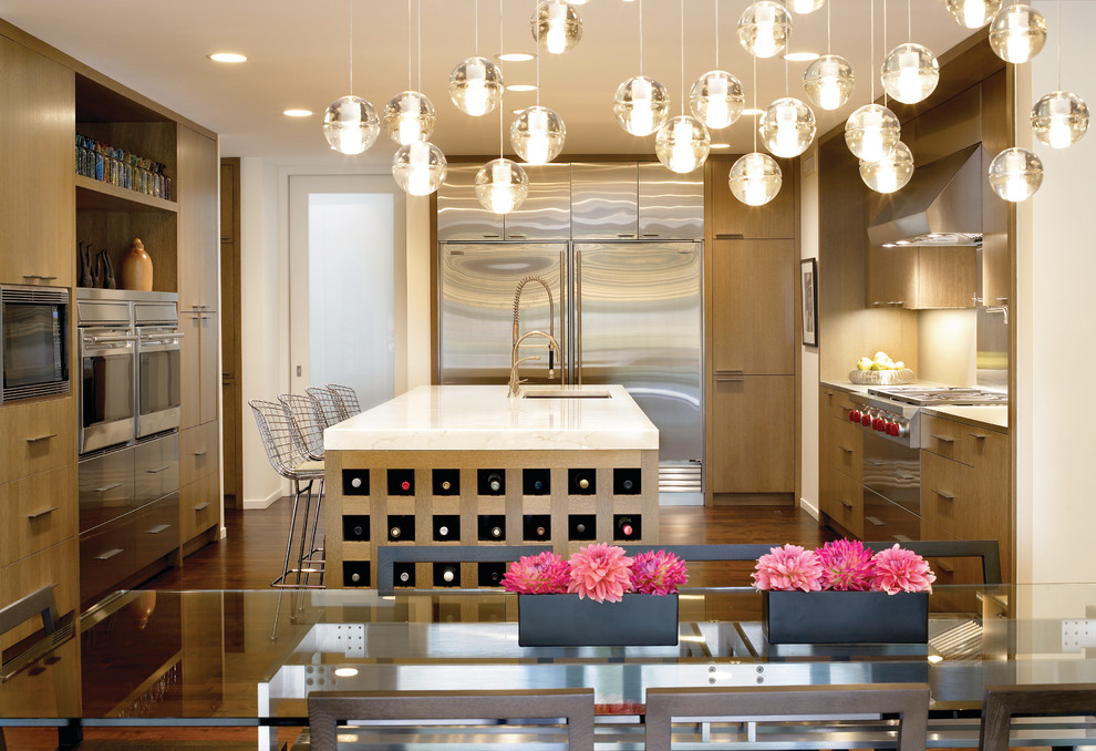 Moderne Wohnküche in U-Form mit flächenbündigen Schrankfronten, Küchengeräten aus Edelstahl und hellen Holzschränken in Chicago