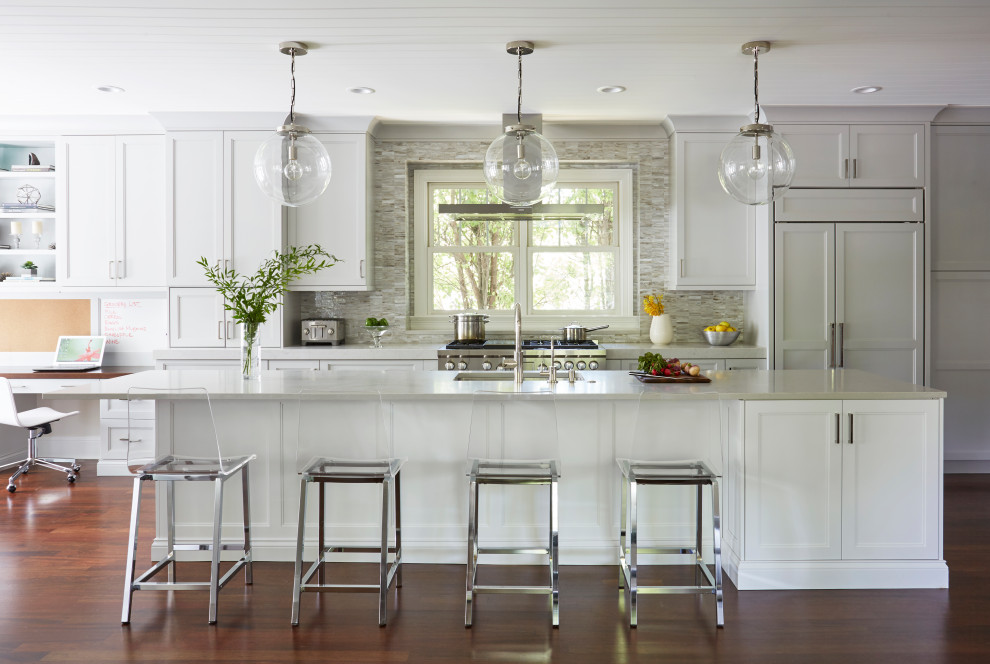 Bild på ett stort vintage grå linjärt grått kök med öppen planlösning, med en köksö, en undermonterad diskho, integrerade vitvaror, mellanmörkt trägolv, luckor med infälld panel, grå skåp, bänkskiva i kvartsit, flerfärgad stänkskydd, stänkskydd i glaskakel och brunt golv