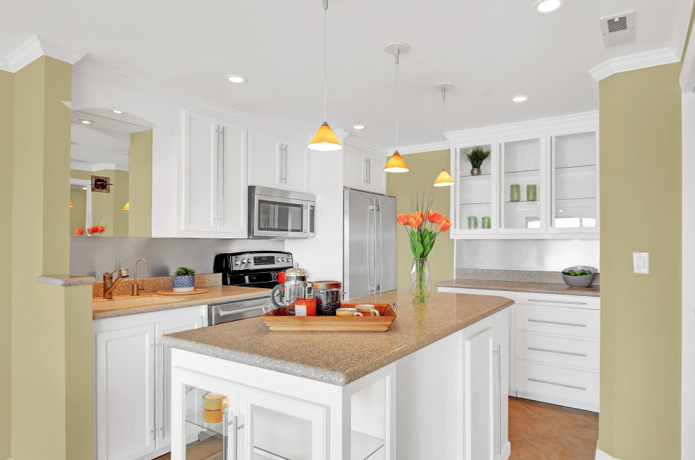 Foto de cocina moderna de tamaño medio con puertas de armario blancas, encimera de granito, salpicadero blanco, electrodomésticos de acero inoxidable, una isla y encimeras beige
