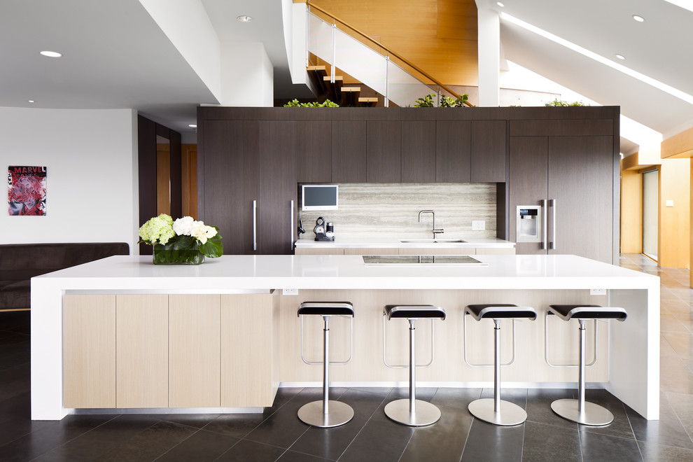 Zweizeilige Moderne Küche mit flächenbündigen Schrankfronten, dunklen Holzschränken, bunter Rückwand und Elektrogeräten mit Frontblende in Vancouver