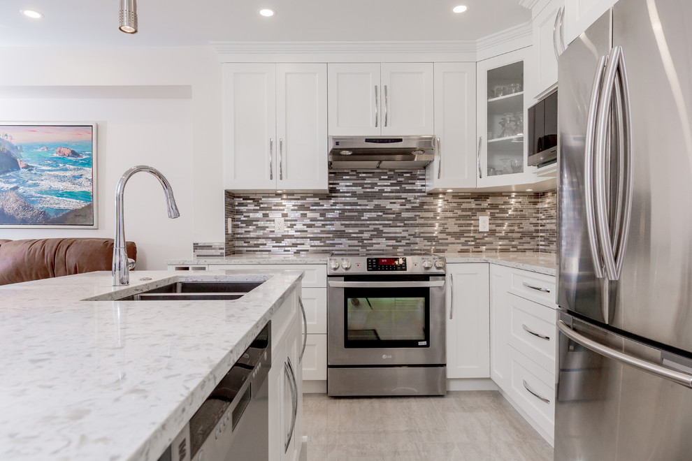 Exempel på ett stort modernt kök, med en undermonterad diskho, skåp i shakerstil, vita skåp, marmorbänkskiva, brunt stänkskydd, stänkskydd i stickkakel, rostfria vitvaror, klinkergolv i porslin, en köksö och beiget golv