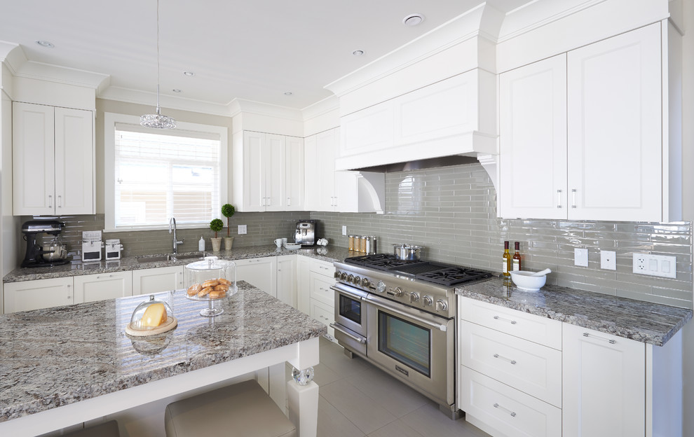 Inspiration for a medium sized traditional l-shaped open plan kitchen in Vancouver with a submerged sink, shaker cabinets, white cabinets, granite worktops, grey splashback, glass tiled splashback, stainless steel appliances, porcelain flooring and an island.