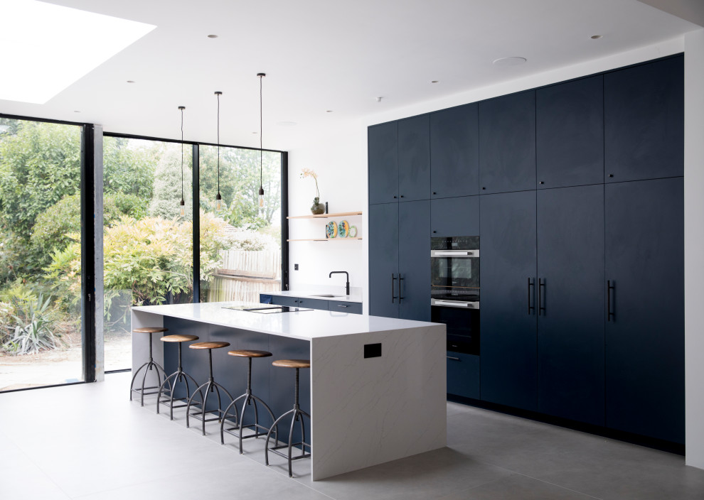 Foto di un'ampia cucina design con lavello integrato, ante lisce, ante blu, top in quarzite, pavimento in cementine, pavimento grigio, top bianco, paraspruzzi bianco e elettrodomestici da incasso