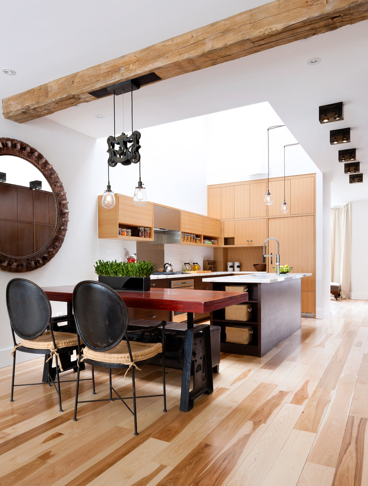 Foto di una cucina minimal con ante lisce, ante in legno chiaro, paraspruzzi bianco, elettrodomestici da incasso e pavimento in legno massello medio