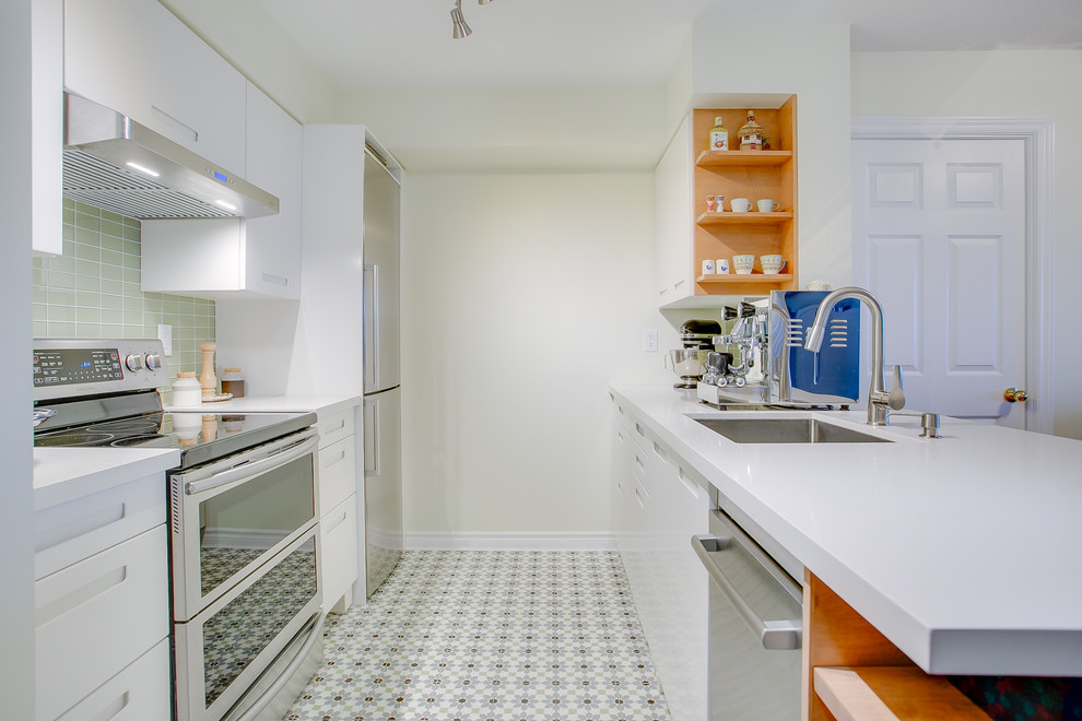 Small trendy galley cement tile floor and multicolored floor eat-in kitchen photo in Toronto with an undermount sink, flat-panel cabinets, white cabinets, quartzite countertops, green backsplash, glass tile backsplash, stainless steel appliances, a peninsula and white countertops