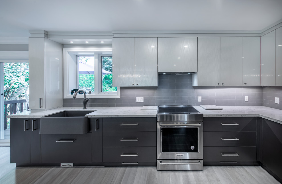 Example of a large minimalist u-shaped vinyl floor and gray floor eat-in kitchen design in Toronto with a farmhouse sink, flat-panel cabinets, white cabinets, quartzite countertops, gray backsplash, subway tile backsplash, stainless steel appliances, an island and white countertops