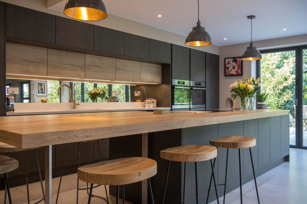 Foto di un cucina con isola centrale design con ante lisce, ante in legno chiaro, top in legno, pavimento con piastrelle in ceramica e pavimento grigio
