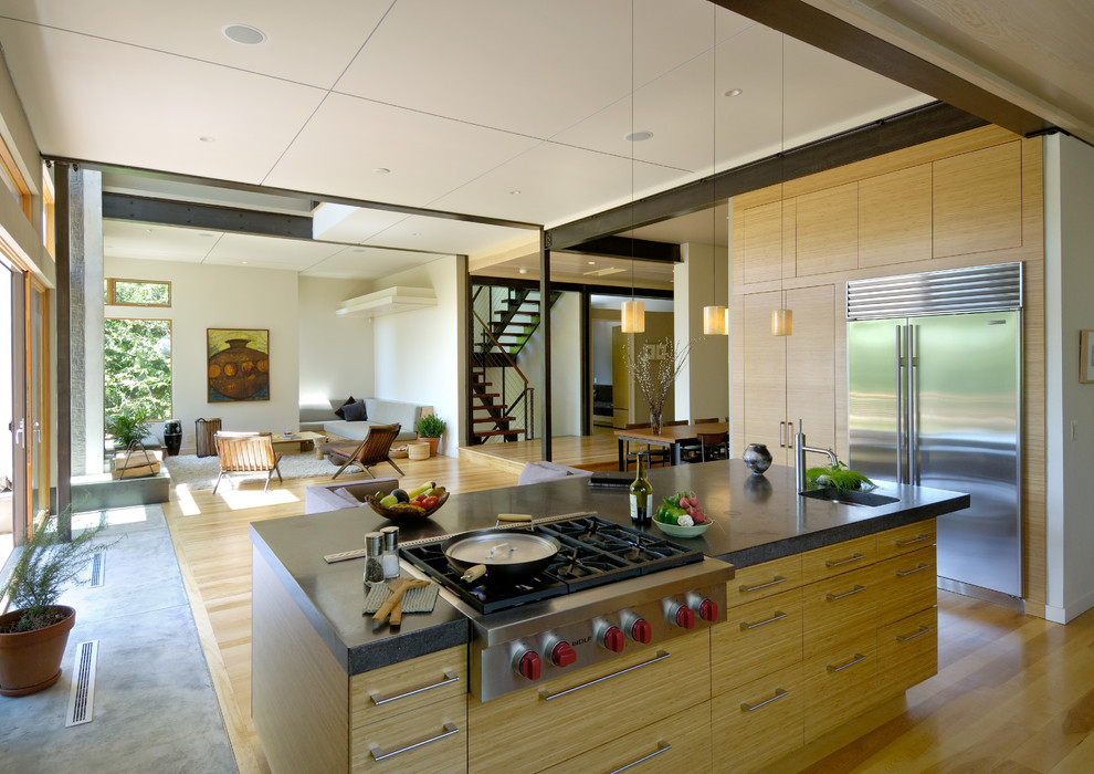 Exempel på ett stort modernt kök med öppen planlösning, med en rustik diskho, släta luckor, beige skåp, bänkskiva i betong, rostfria vitvaror, bambugolv och en köksö
