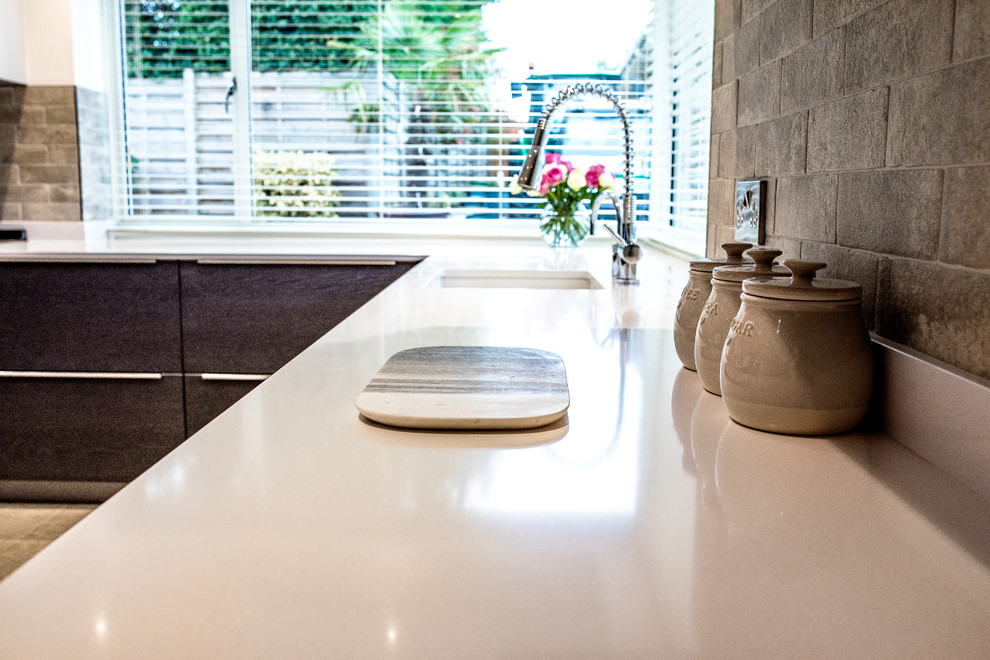 Exempel på ett mellanstort modernt vit vitt kök, med en enkel diskho, släta luckor, skåp i mellenmörkt trä, bänkskiva i kvartsit, beige stänkskydd, stänkskydd i stenkakel, svarta vitvaror, klinkergolv i porslin, en köksö och beiget golv