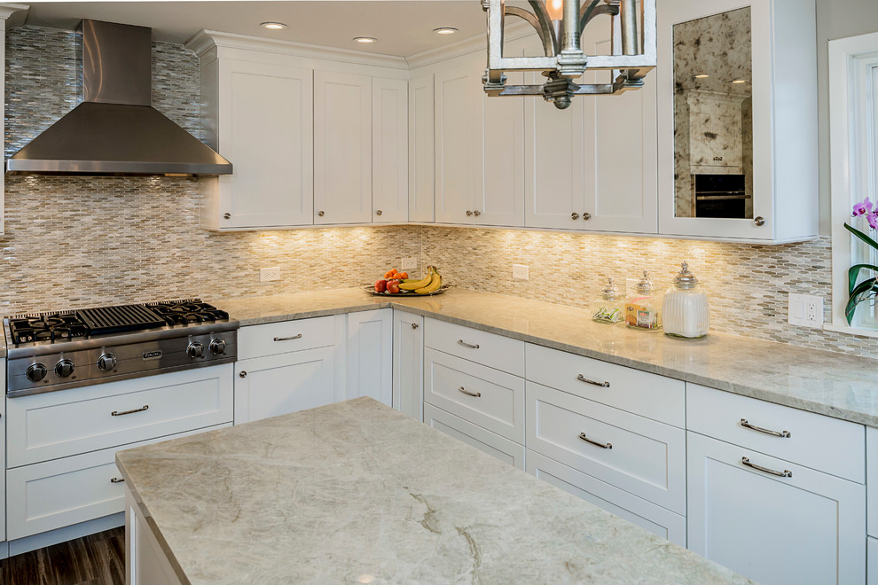 Inspiration for a large transitional galley porcelain tile eat-in kitchen remodel in Chicago with a farmhouse sink, shaker cabinets, white cabinets, quartzite countertops, multicolored backsplash, glass sheet backsplash, stainless steel appliances and an island