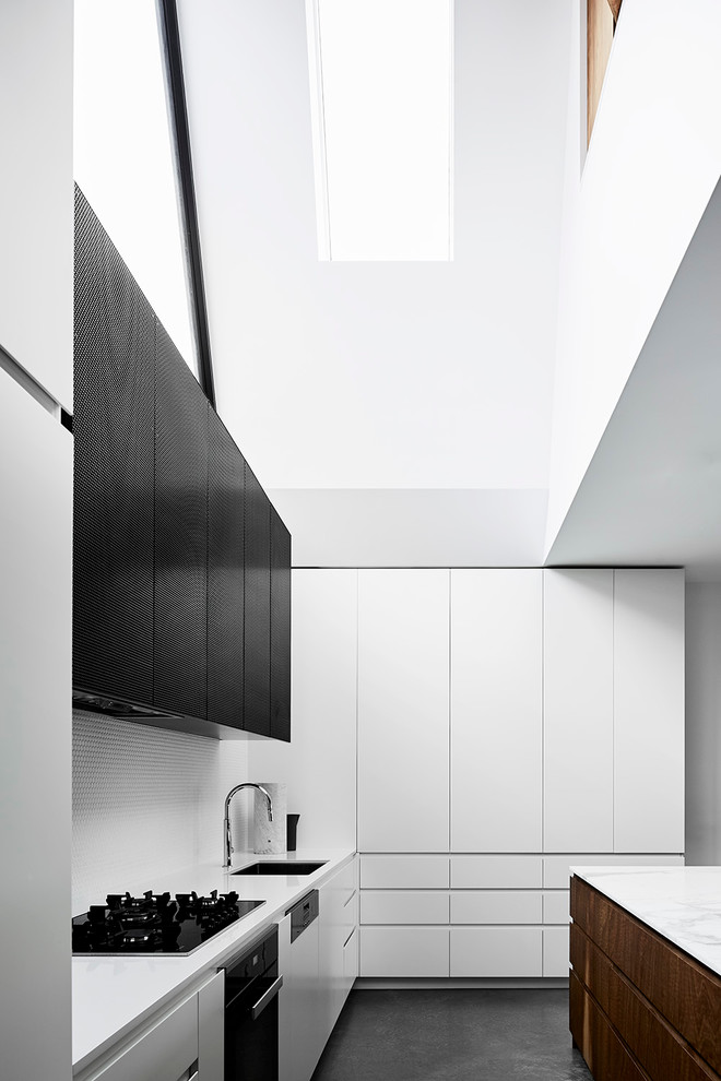 Photo of a medium sized contemporary u-shaped kitchen/diner in Melbourne with a submerged sink, flat-panel cabinets, white cabinets, marble worktops, white splashback, mosaic tiled splashback, stainless steel appliances, concrete flooring and an island.