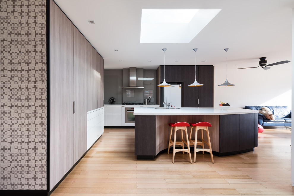 Mittelgroße Moderne Küche in L-Form mit dunklen Holzschränken, Küchenrückwand in Grau, Glasrückwand, Küchengeräten aus Edelstahl und Kücheninsel in Melbourne