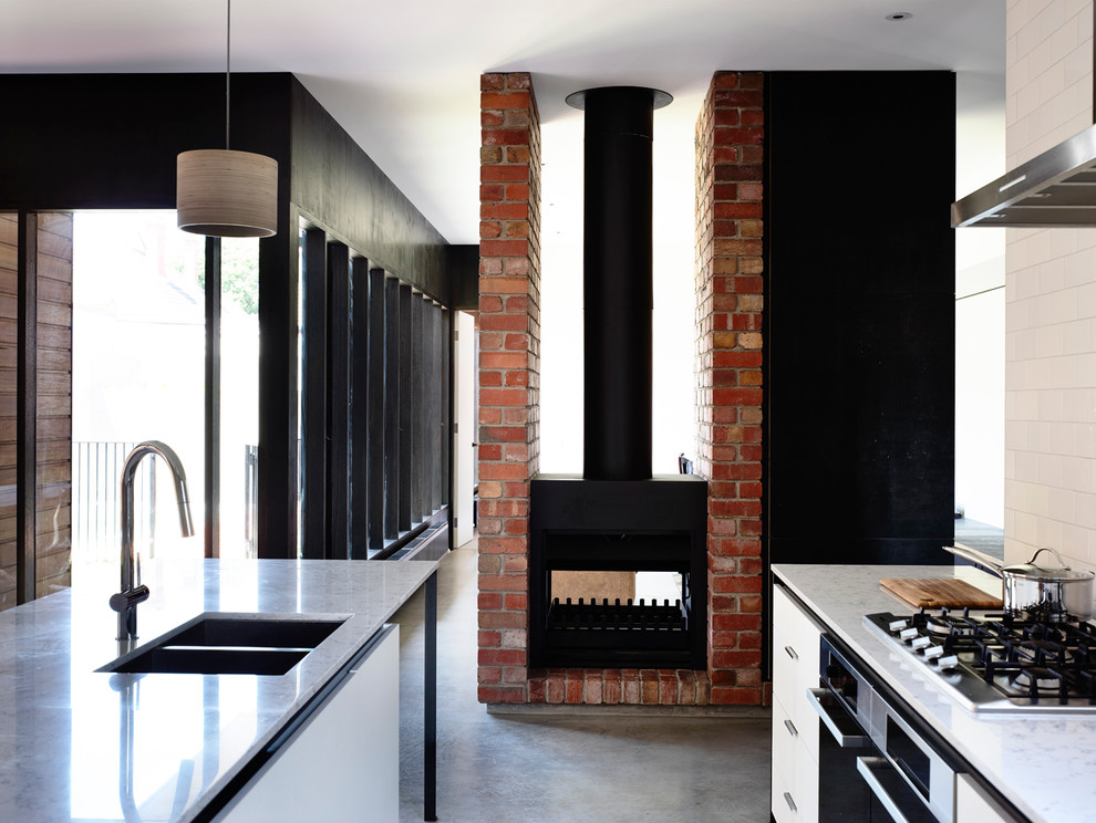 Eat-in kitchen - mid-sized contemporary galley concrete floor eat-in kitchen idea in Melbourne with an undermount sink, flat-panel cabinets, white cabinets, quartz countertops, white backsplash, subway tile backsplash, stainless steel appliances and an island