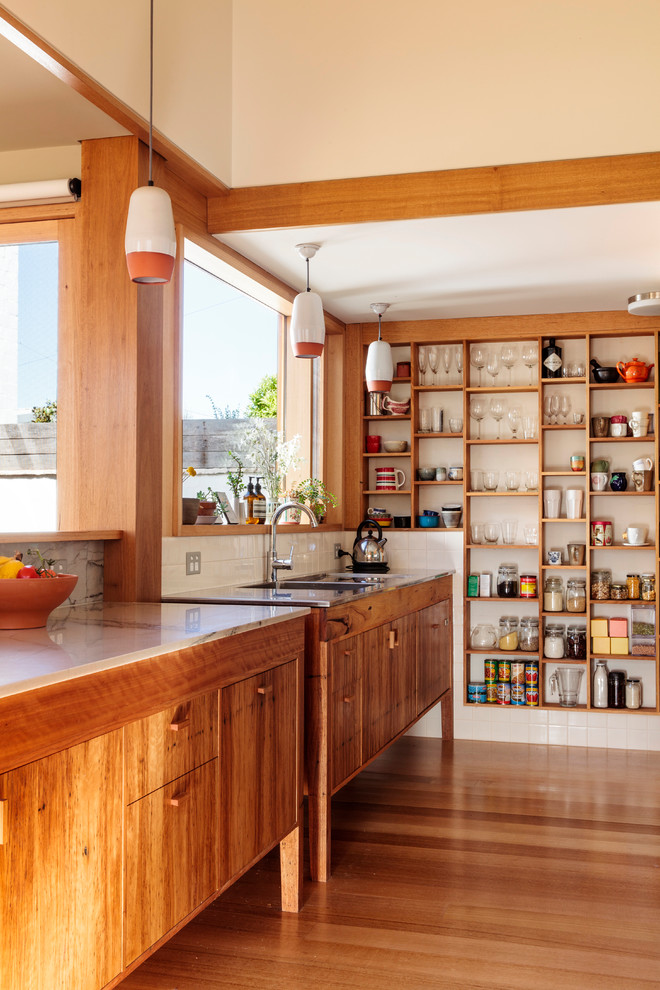 Inredning av ett eklektiskt litet kök, med en integrerad diskho, luckor med infälld panel, skåp i ljust trä, marmorbänkskiva, blått stänkskydd, stänkskydd i keramik, rostfria vitvaror, ljust trägolv och en halv köksö