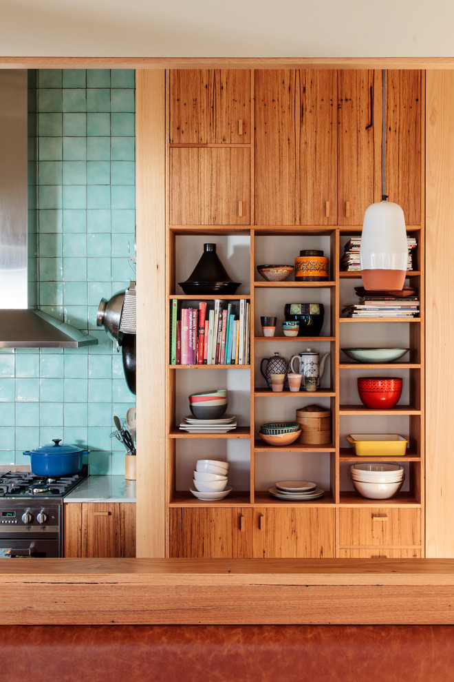 Exempel på ett litet modernt kök, med en undermonterad diskho, luckor med infälld panel, skåp i ljust trä, marmorbänkskiva, blått stänkskydd, stänkskydd i keramik, rostfria vitvaror, ljust trägolv och en halv köksö