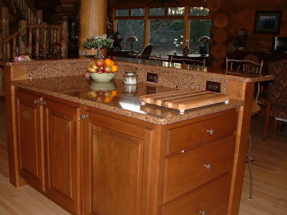 Mountain style l-shaped eat-in kitchen photo in Other with a single-bowl sink, raised-panel cabinets, dark wood cabinets, quartz countertops and stainless steel appliances
