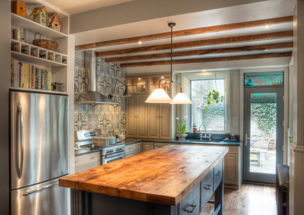 Foto de cocinas en L tradicional con armarios con paneles con relieve, encimera de madera, puertas de armario azules, salpicadero azul, electrodomésticos de acero inoxidable y de obra