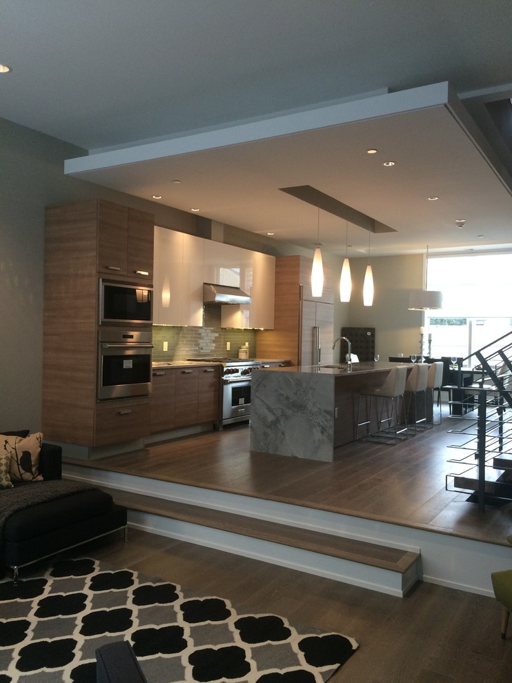Example of a large minimalist galley light wood floor eat-in kitchen design in Philadelphia with an island, flat-panel cabinets, light wood cabinets, quartz countertops, green backsplash, glass tile backsplash and a single-bowl sink