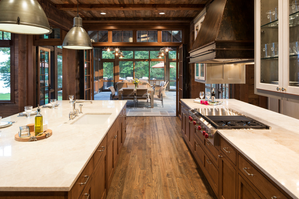 Inspiration for a rustic u-shaped medium tone wood floor eat-in kitchen remodel in Minneapolis with granite countertops, paneled appliances and two islands