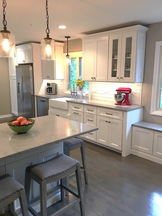 Idéer för att renovera ett mellanstort maritimt grå grått kök, med en rustik diskho, skåp i shakerstil, vita skåp, bänkskiva i kvarts, vitt stänkskydd, stänkskydd i porslinskakel, rostfria vitvaror, mellanmörkt trägolv, en halv köksö och grått golv