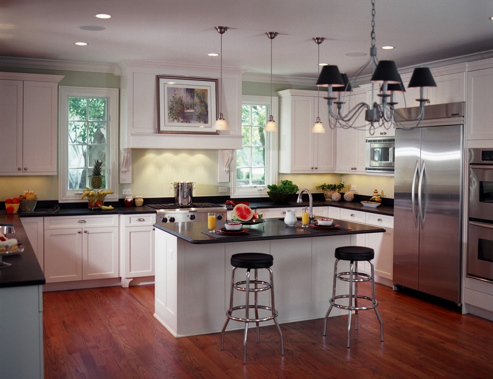 Inspiration for a mid-sized timeless u-shaped dark wood floor eat-in kitchen remodel in Chicago with a double-bowl sink, shaker cabinets, white cabinets, soapstone countertops, green backsplash, stainless steel appliances and an island