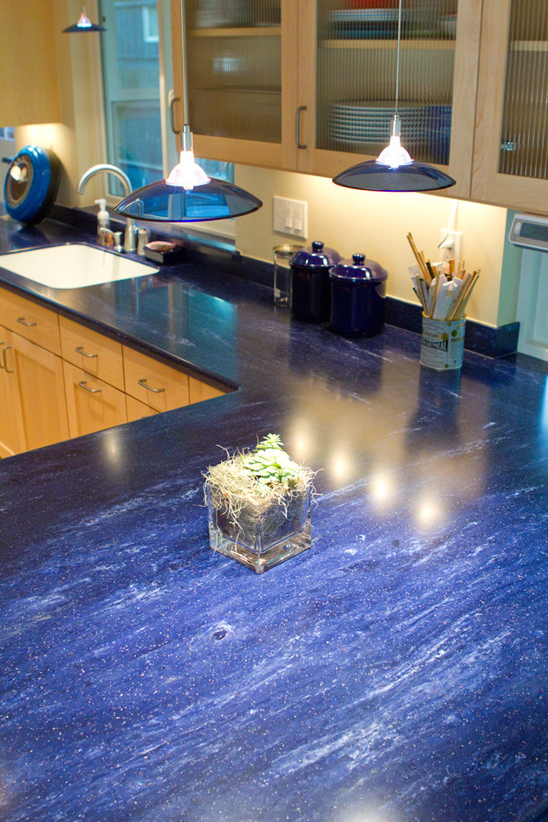 Inredning av ett eklektiskt mellanstort blå blått kök, med en enkel diskho, skåp i shakerstil, skåp i ljust trä, bänkskiva i koppar, blått stänkskydd, rostfria vitvaror, ljust trägolv och en köksö
