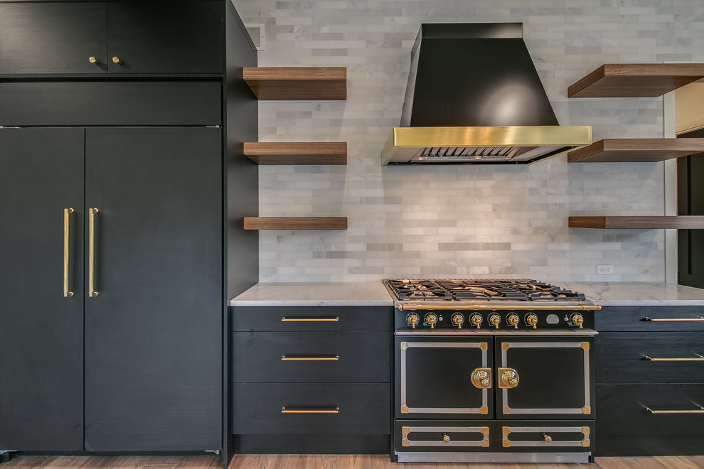 Large contemporary l-shaped open plan kitchen in Detroit with an integrated sink, flat-panel cabinets, black cabinets, marble worktops, grey splashback, marble splashback, black appliances, medium hardwood flooring, an island, brown floors and grey worktops.