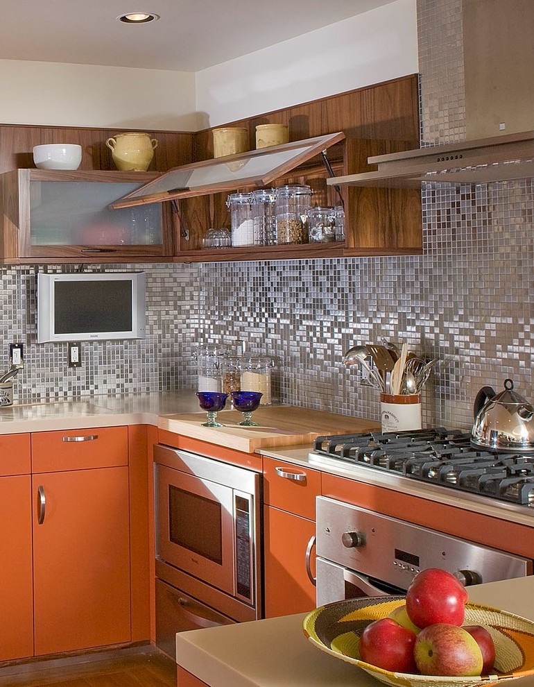 На фото: п-образная кухня среднего размера с обеденным столом, врезной мойкой и оранжевыми фасадами с