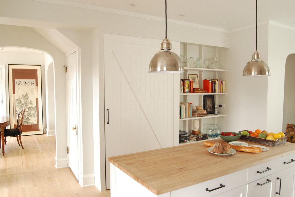 Modelo de cocina de estilo de casa de campo con armarios abiertos, puertas de armario blancas y encimera de madera
