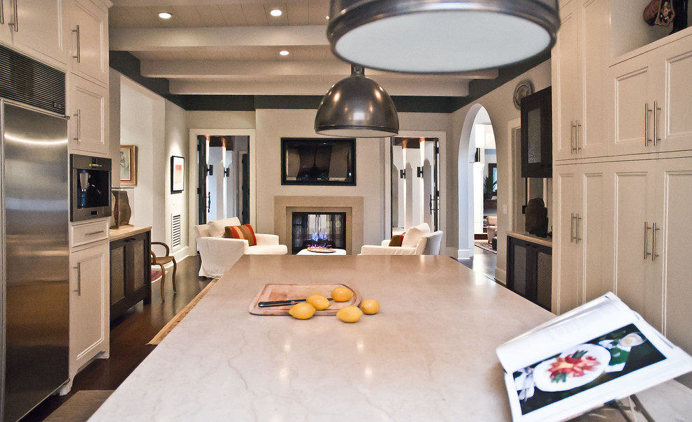 Eclectic u-shaped open concept kitchen photo in Nashville with an integrated sink, recessed-panel cabinets, white cabinets, limestone countertops and stainless steel appliances